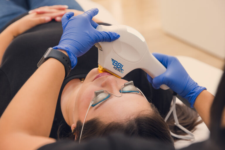 Provider wearing gloves places a laser hair removal Near Centennial Hills on patient's face. Patient is laying on back and wearing protective eyewear.