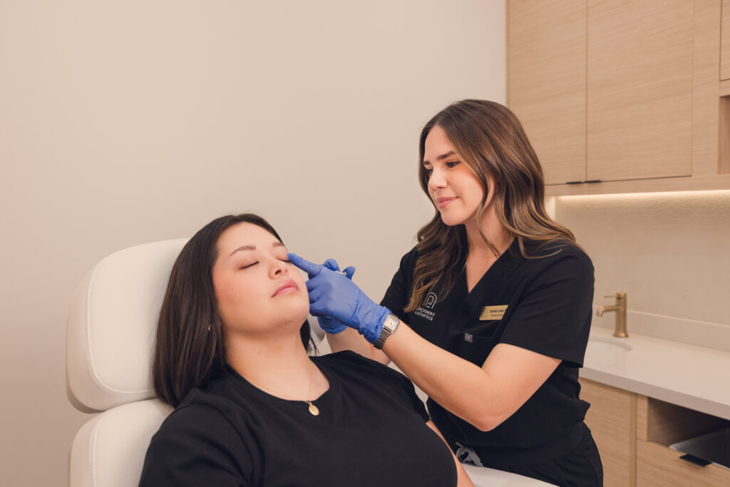 Woman receiving facial balancing treatment from a provider.