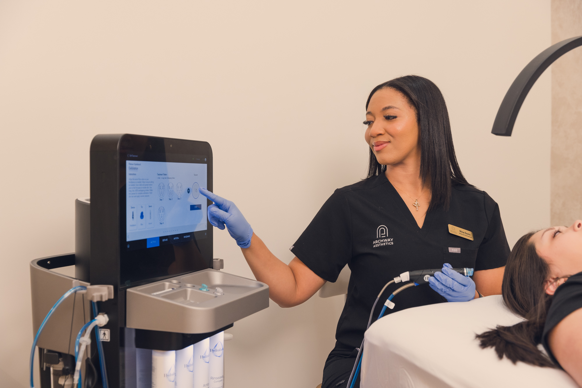 Archway Aesthetics employee prepping Hydrafacial device to use on client.