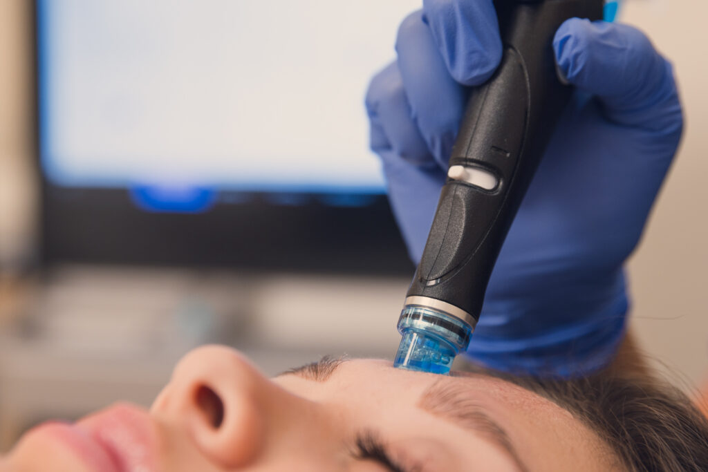 A woman relaxes at our facial spa in Las Vegas as she receives a Hydrafacial, which provides deep exfoliation and cleansing.